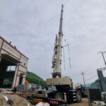 충주 건설 현장에서 25톤 크레인이 철골 구조물을 인양하는 모습