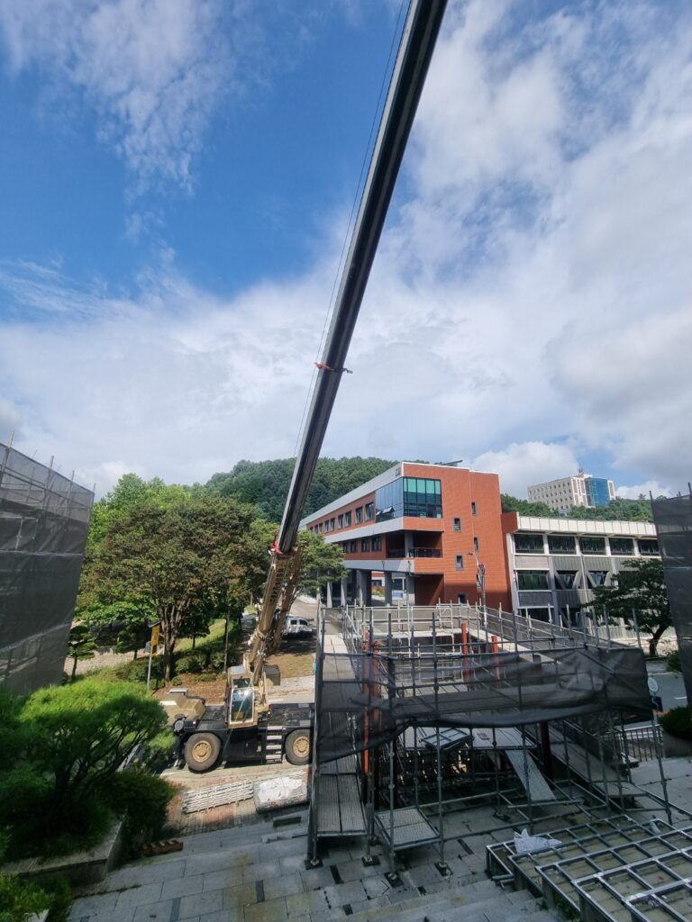 충주 25톤크레인의 붐이 길게 뻗어 정밀 작업을 수행하는 모습